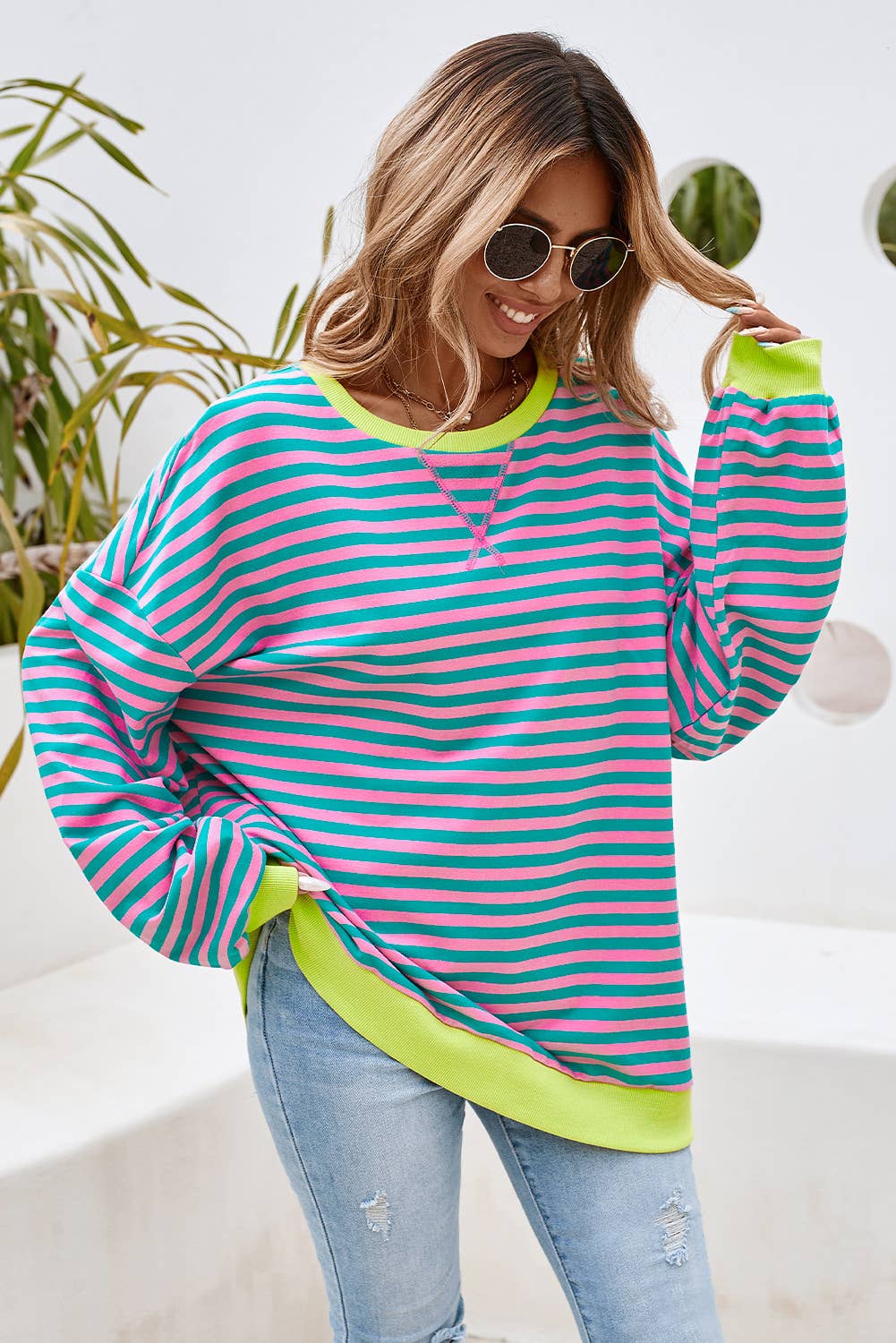 This colorful striped top is both stylish and comfortable. This top features a combination of blue, yellow, and green stripes, making it a vibrant and eye-catching piece.