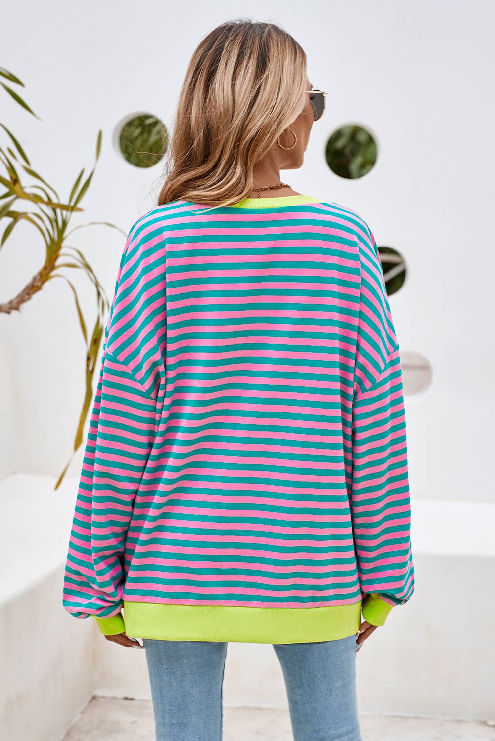 This colorful striped top is both stylish and comfortable. This top features a combination of blue, yellow, and green stripes, making it a vibrant and eye-catching piece.