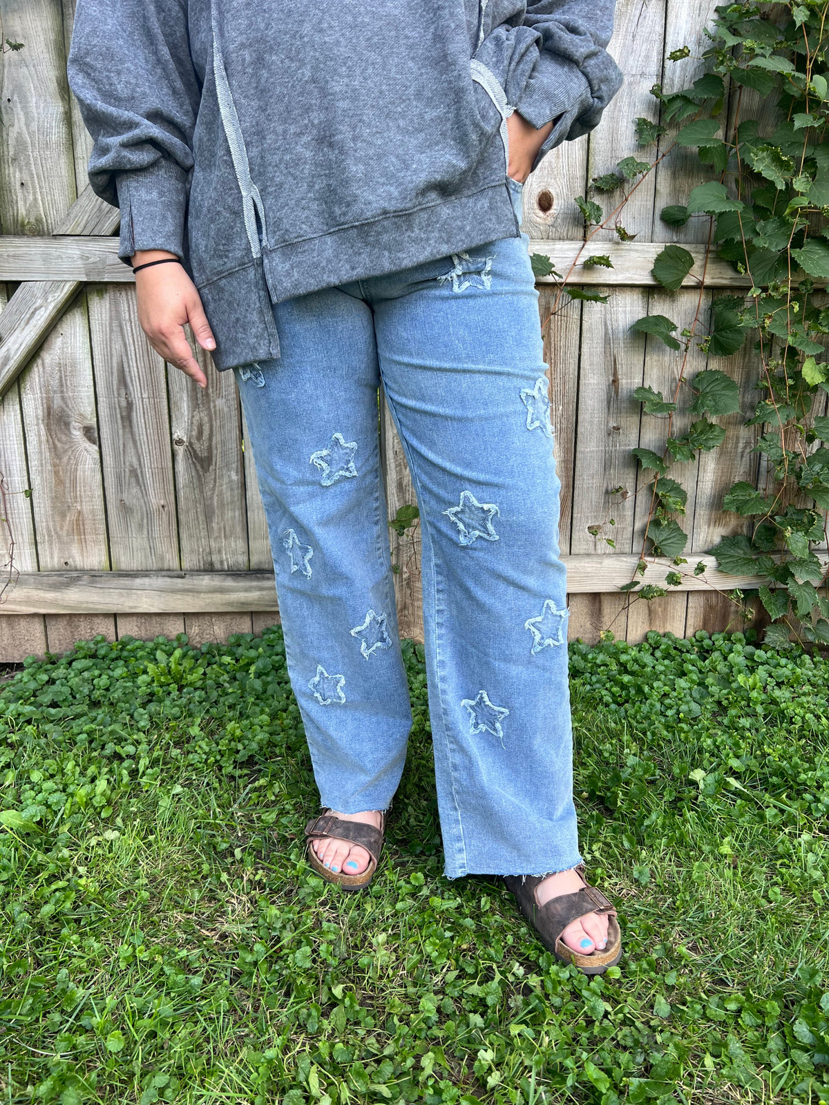 Women's western-inspired straight leg jeans featuring star details on the front, pockets, and a stretchy waistband.