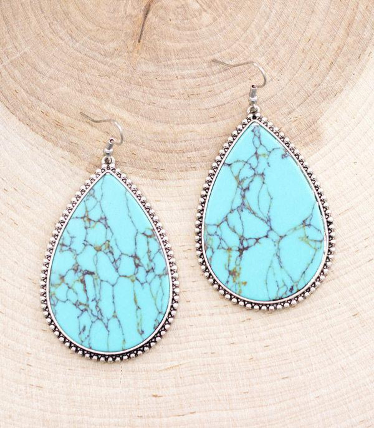 Pair of turquoise-colored teardrop dangle earrings with semi-stone accents, casting hooks, and an approximate 3-inch drop.