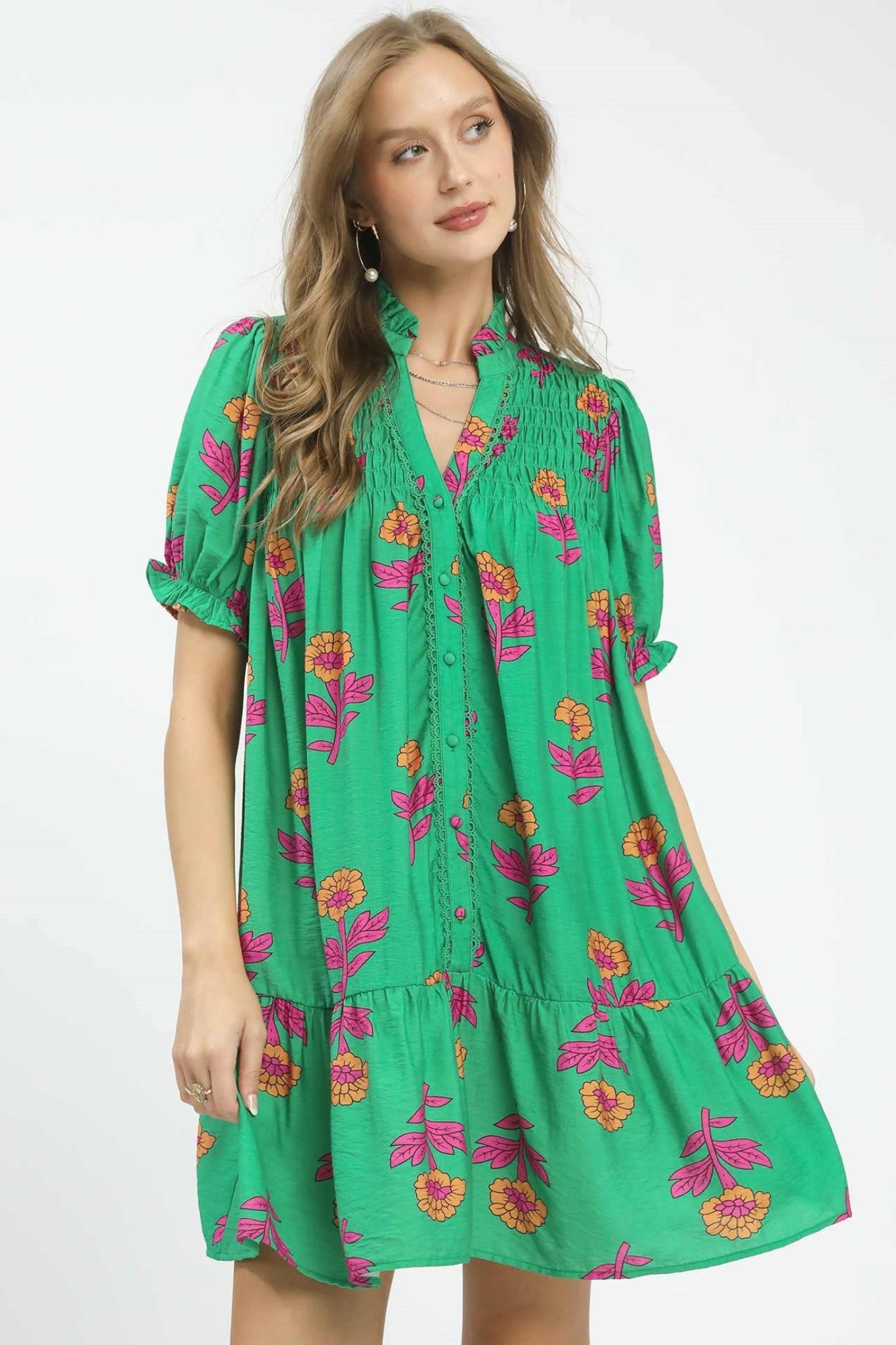 Green floral baby-doll mini dress with pink and orange flowers, smocked yoke, button front detail, and short puff sleeves, flowy and lightweight for spring and summer