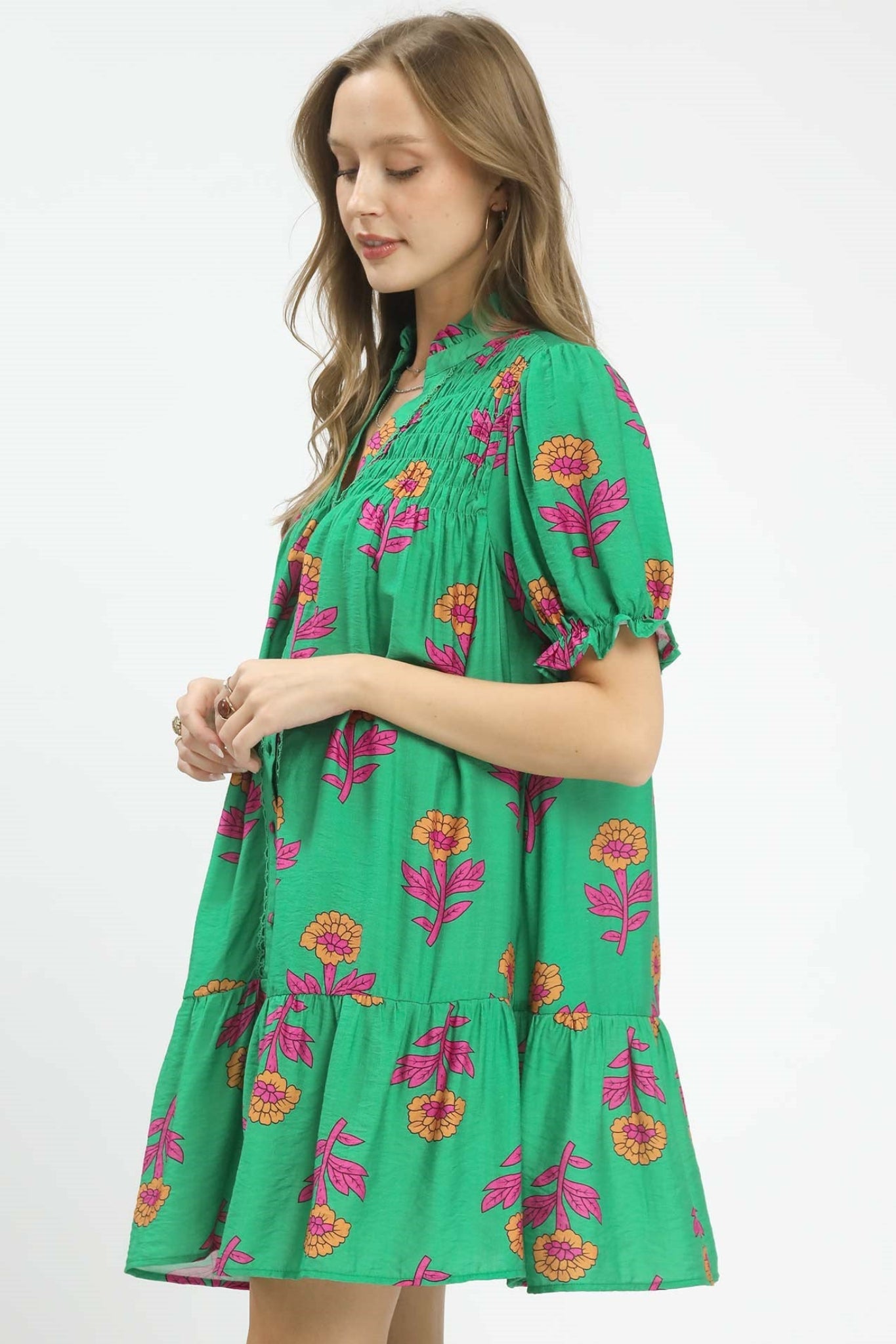 Green floral baby-doll mini dress with pink and orange flowers, smocked yoke, button front detail, and short puff sleeves, flowy and lightweight for spring and summer