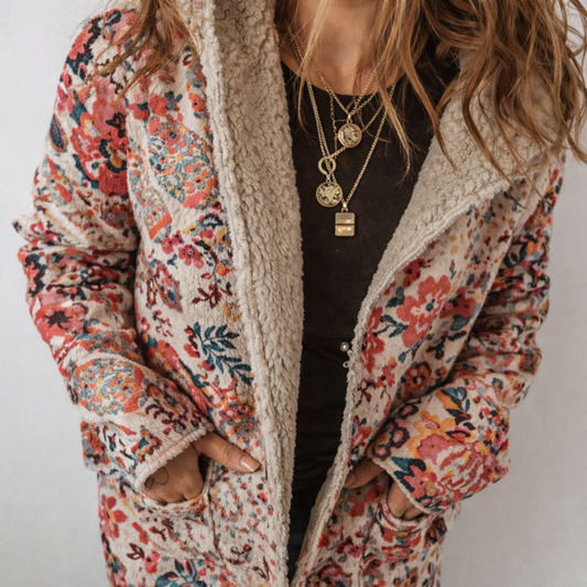 Person wearing a floral patterned coat with a neutral background