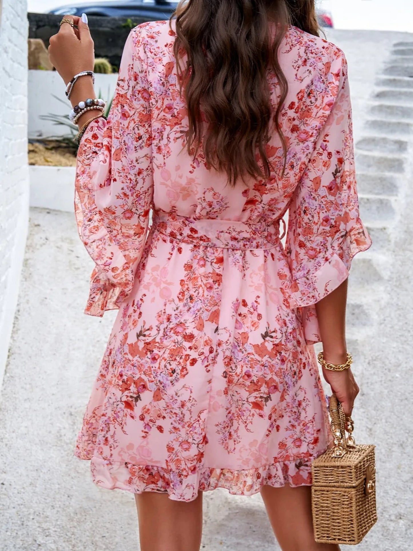 Floral wrap mini dress with ruffle sleeves, tie waist, and V-neckline in multiple color options, lightweight and flowy for spring and summer wear