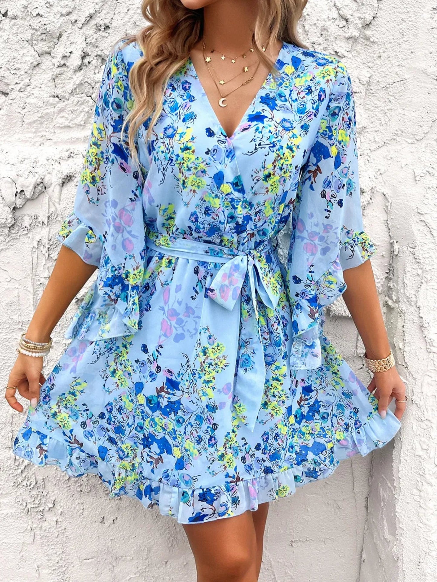 Floral wrap mini dress with ruffle sleeves, tie waist, and V-neckline in multiple color options, lightweight and flowy for spring and summer wear