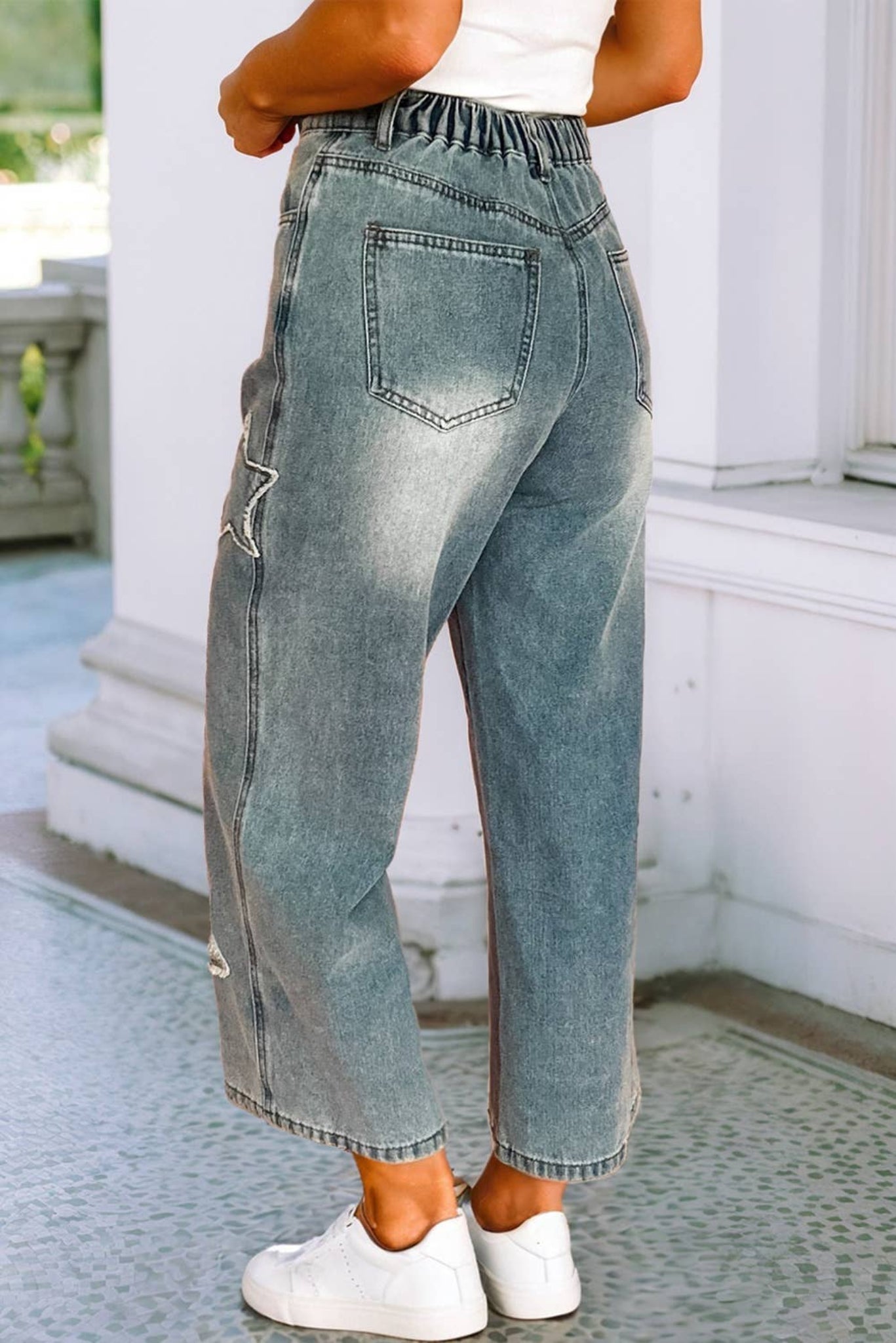Person wearing light blue jeans with a white background