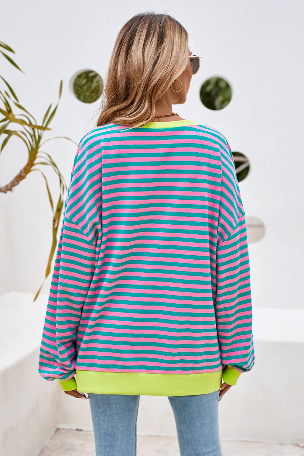 This colorful striped top is both stylish and comfortable. This top features a combination of blue, yellow, and green stripes, making it a vibrant and eye-catching piece.
