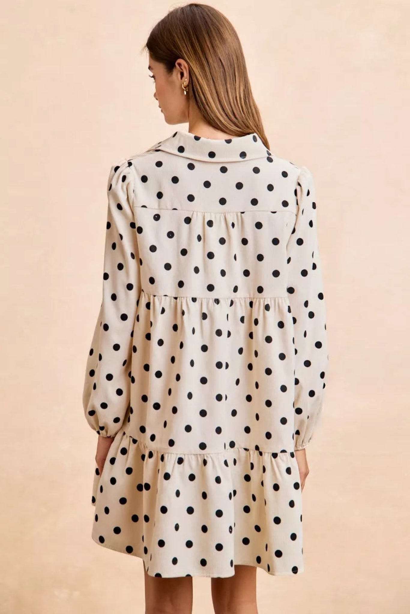 Cream polka dot baby-doll mini dress with black dots, long puff sleeves, tiered skirt, and lightweight flowy fit for everyday wear