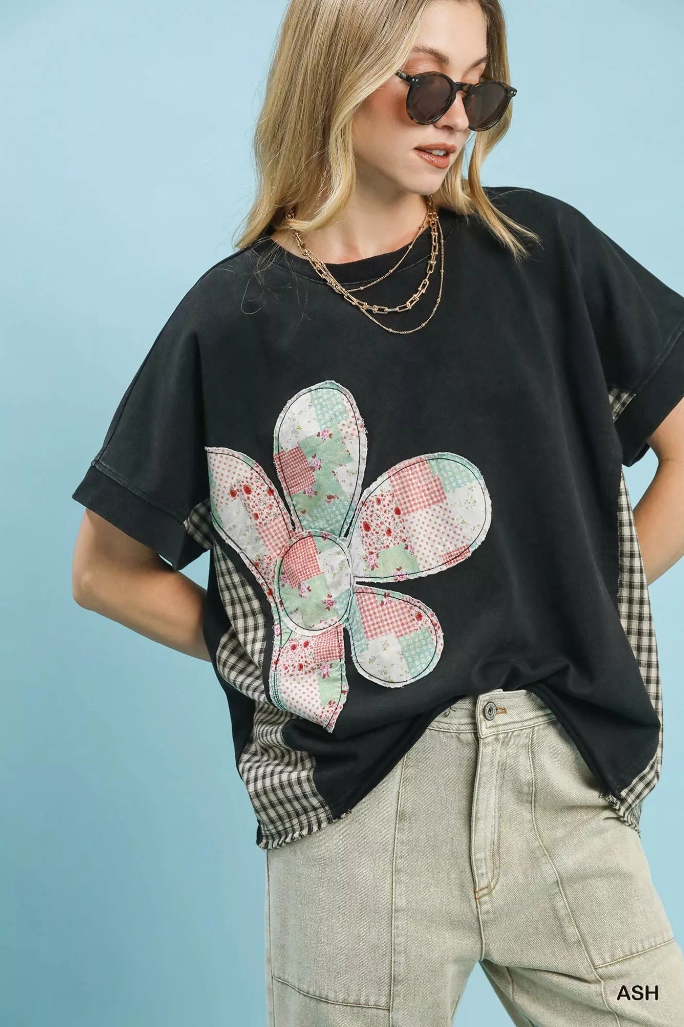 Umgee black short sleeve top featuring patchwork floral applique detail, relaxed oversized fit, and casual everyday style.