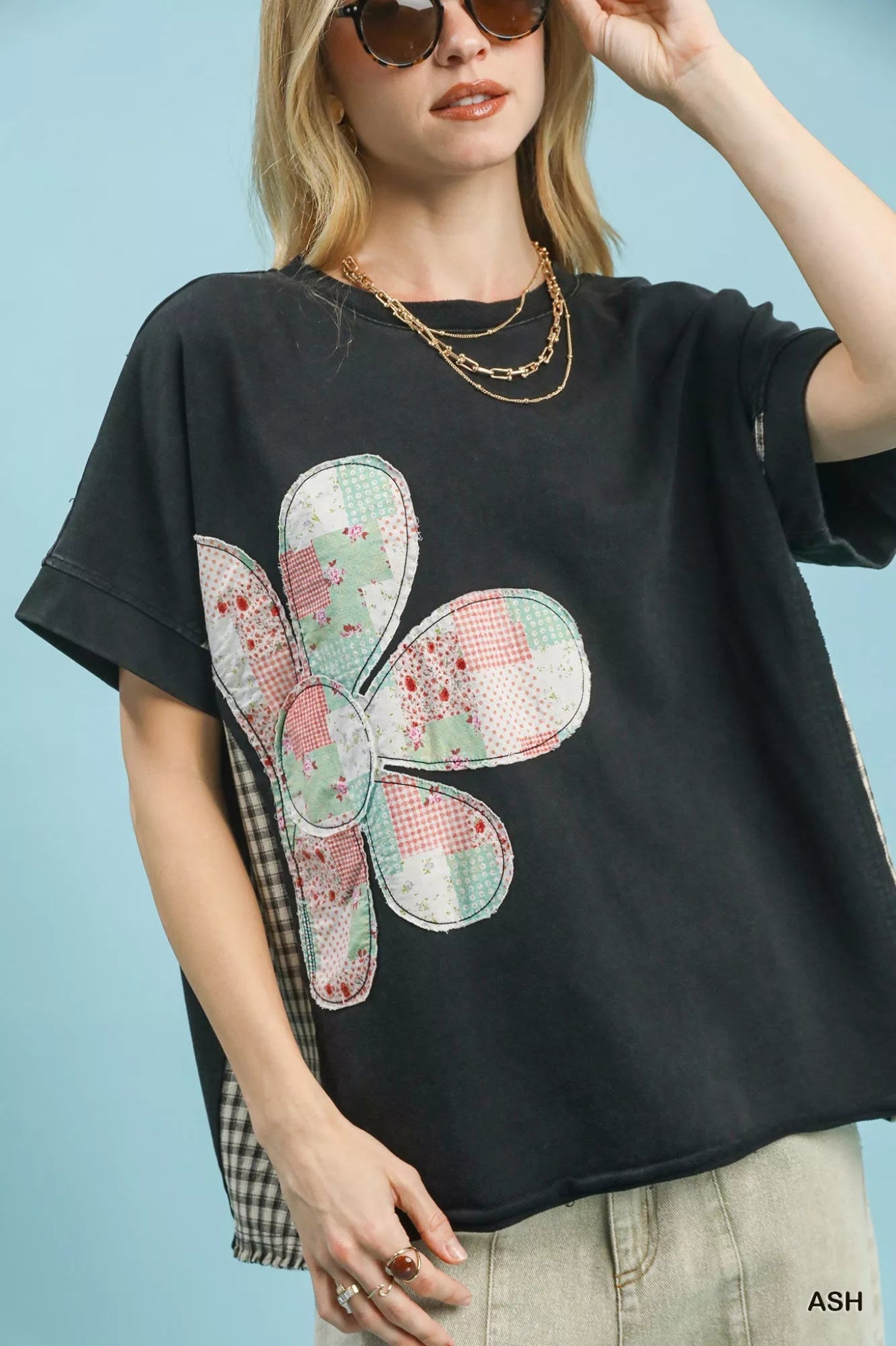 Umgee black short sleeve top featuring patchwork floral applique detail, relaxed oversized fit, and casual everyday style.