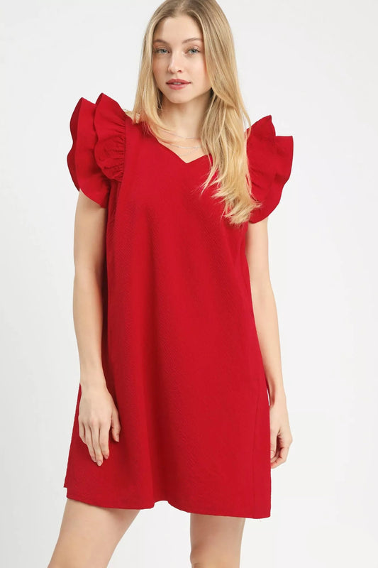 Woman wearing a red V-neck shift dress with ruffle flutter sleeves and a relaxed fit, styled for a casual boutique look.