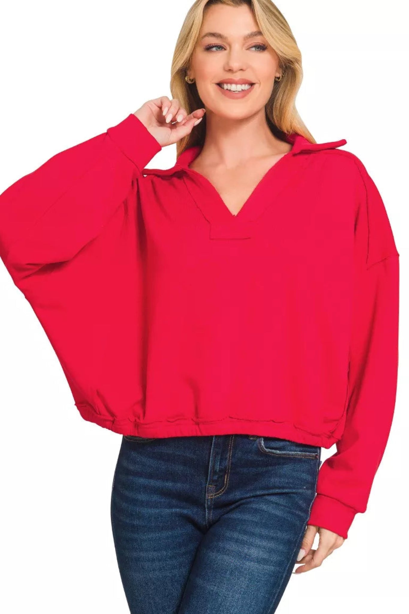 Ruby red long sleeve dolman top with v-neckline, elastic hem, and relaxed fit on a model against a white background