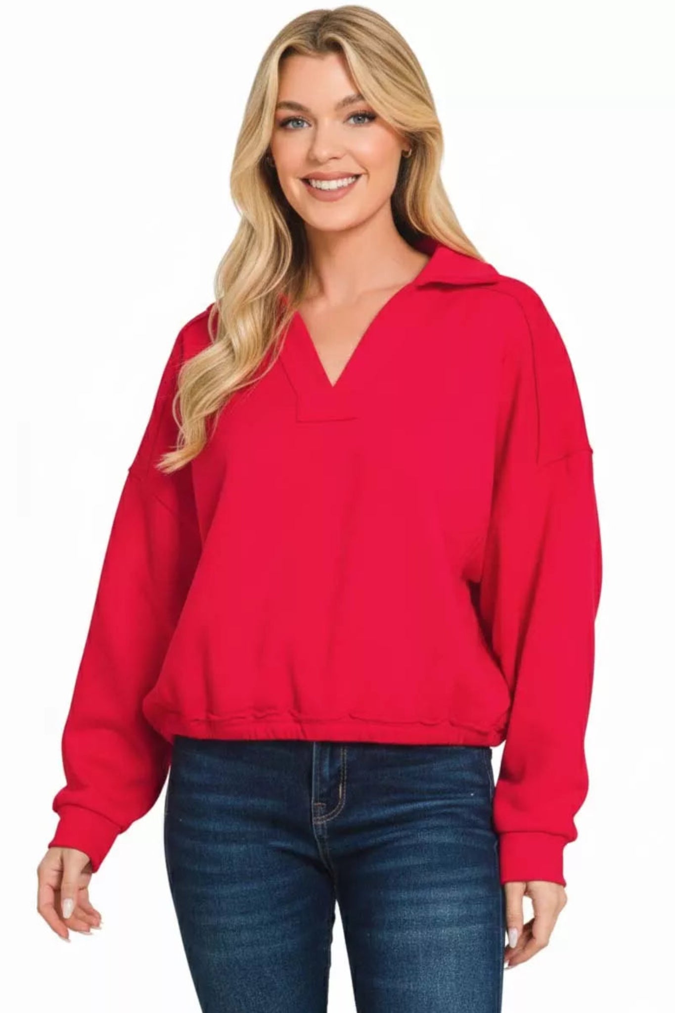 Ruby red long sleeve dolman top with v-neckline, elastic hem, and relaxed fit on a model against a white background