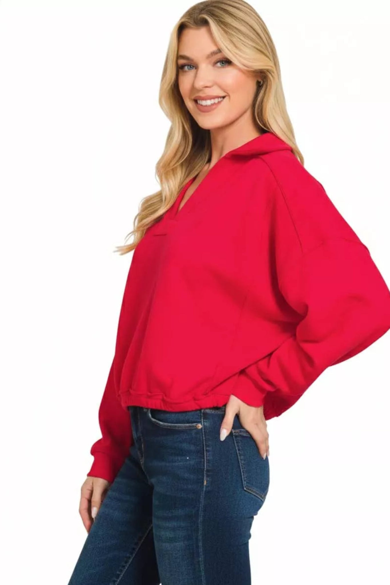 Ruby red long sleeve dolman top with v-neckline, elastic hem, and relaxed fit on a model against a white background