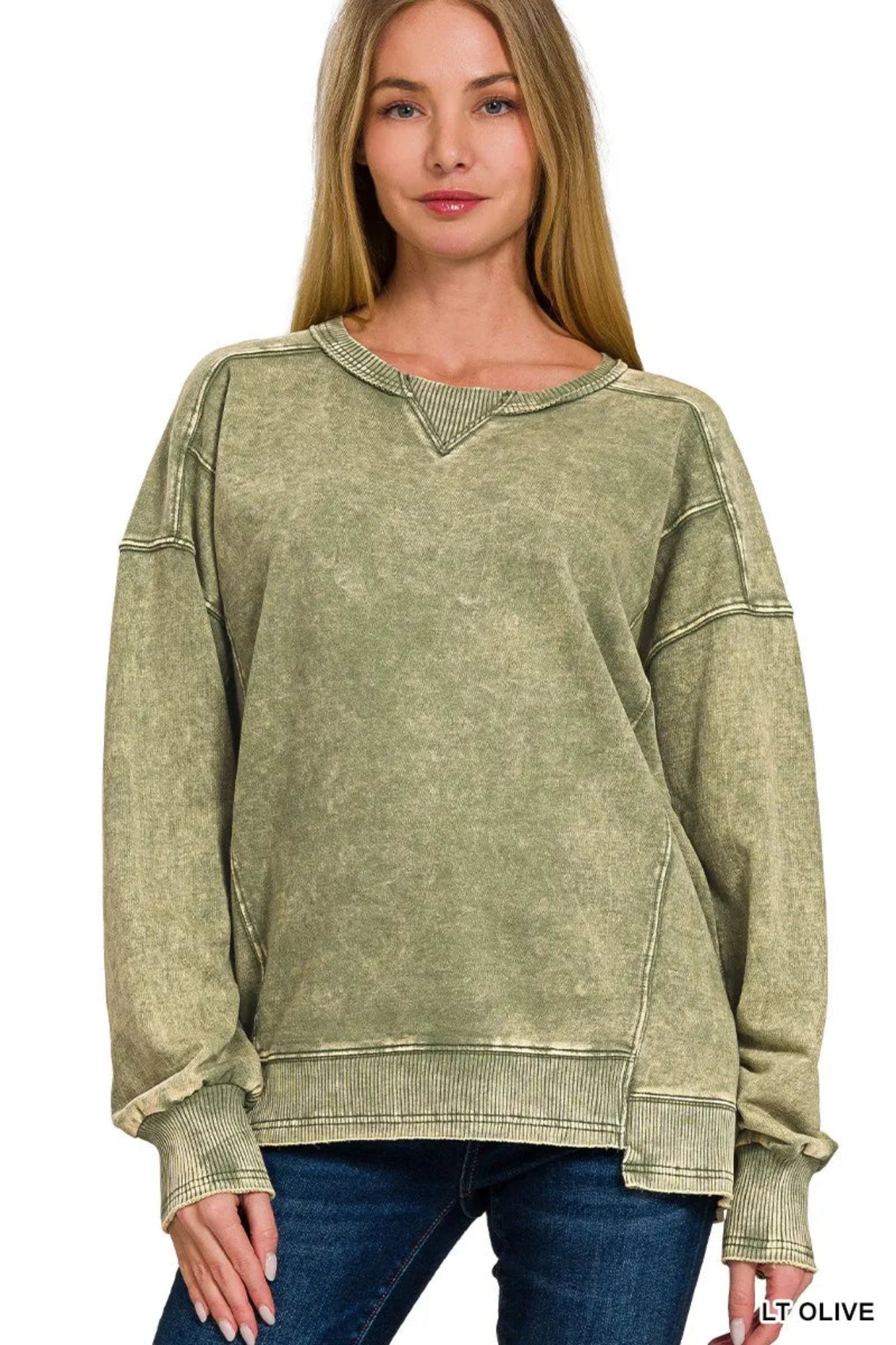 Woman wearing a olive washed long sleeve pullover sweatshirt with relaxed fit, ribbed cuffs and hem, and casual everyday style.