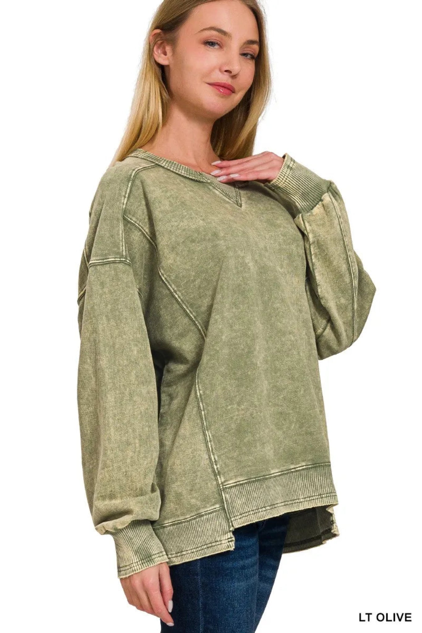 Woman wearing a olive washed long sleeve pullover sweatshirt with relaxed fit, ribbed cuffs and hem, and casual everyday style.