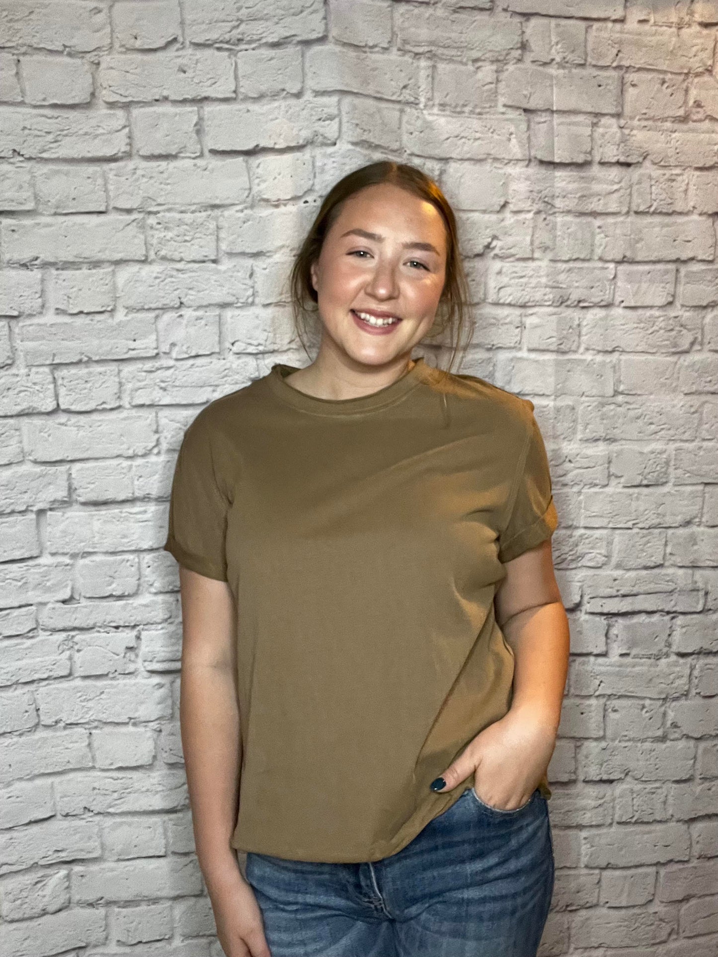 A woman wearing a simple brown short-sleeve tee with a relaxed fit.