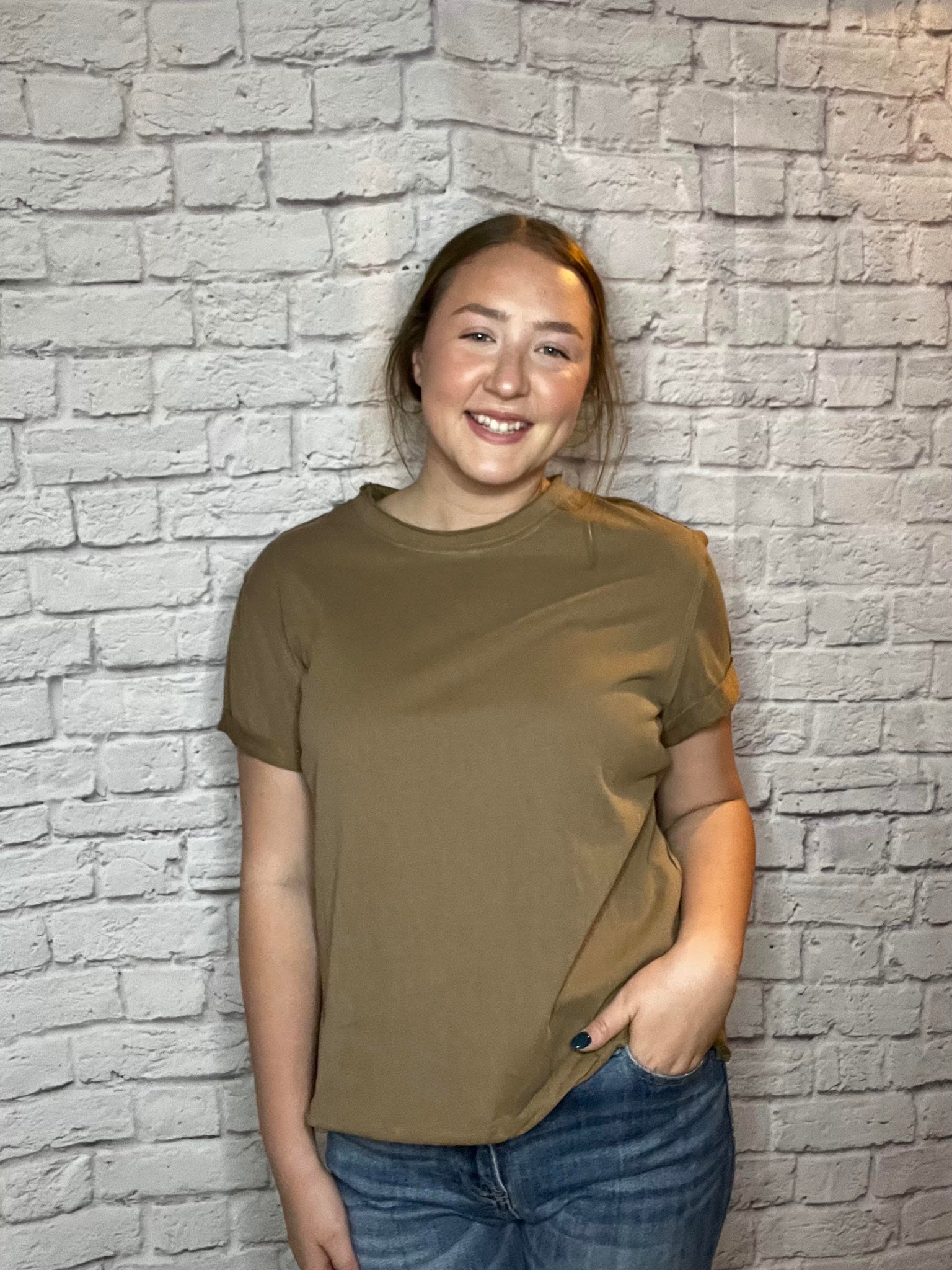 A woman wearing a simple brown short-sleeve tee with a relaxed fit.