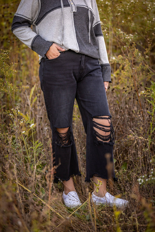 distressed black denim with frayed bottoms - cropped with holes in the knees 